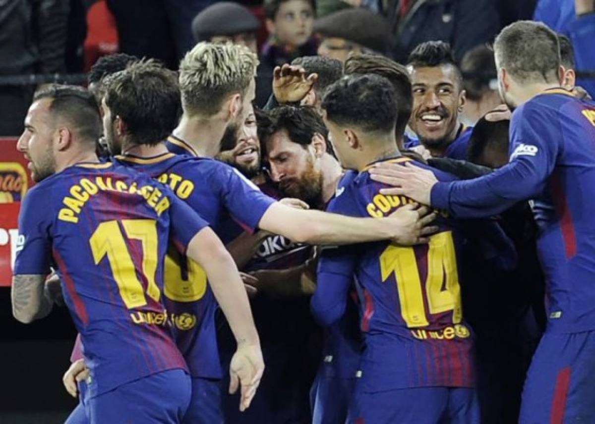 Barcelona's Argentinian forward Lionel Messi (C) celebrates a goal with teammates during the Spanish League football match between Sevilla FC and FC Barcelona at the Ramon Sanchez Pizjuan stadium on March 31, 2018. / AFP PHOTO / Cristina Quicler