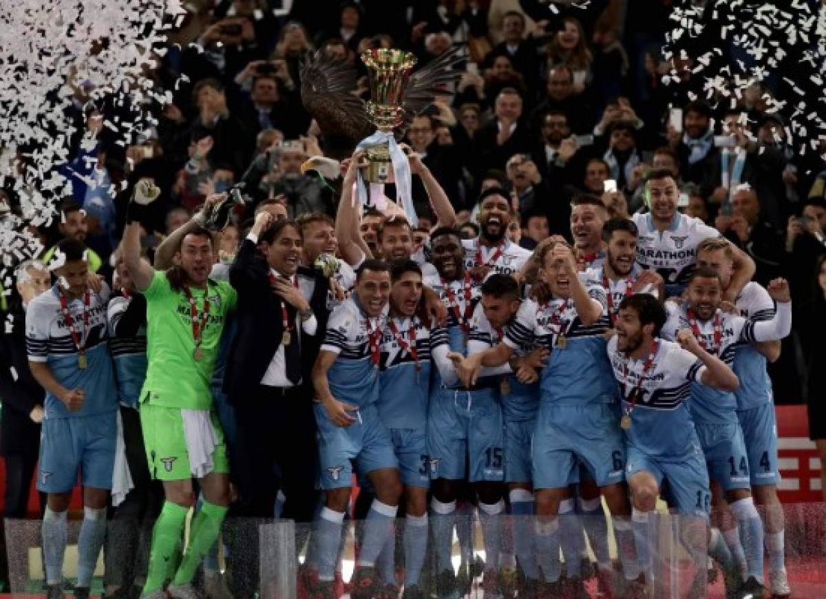 Lazio's Italian coach Simone Inzaghi and his team players celebrate as they hold the Tim Cup trophy during the trophy ceremony after winning at the end of the Italian Tim Cup final match between Lazio and Atalanta, on May 15, 2019 at the Olympic Stadium in Rome. (Photo by Isabella BONOTTO / AFP)