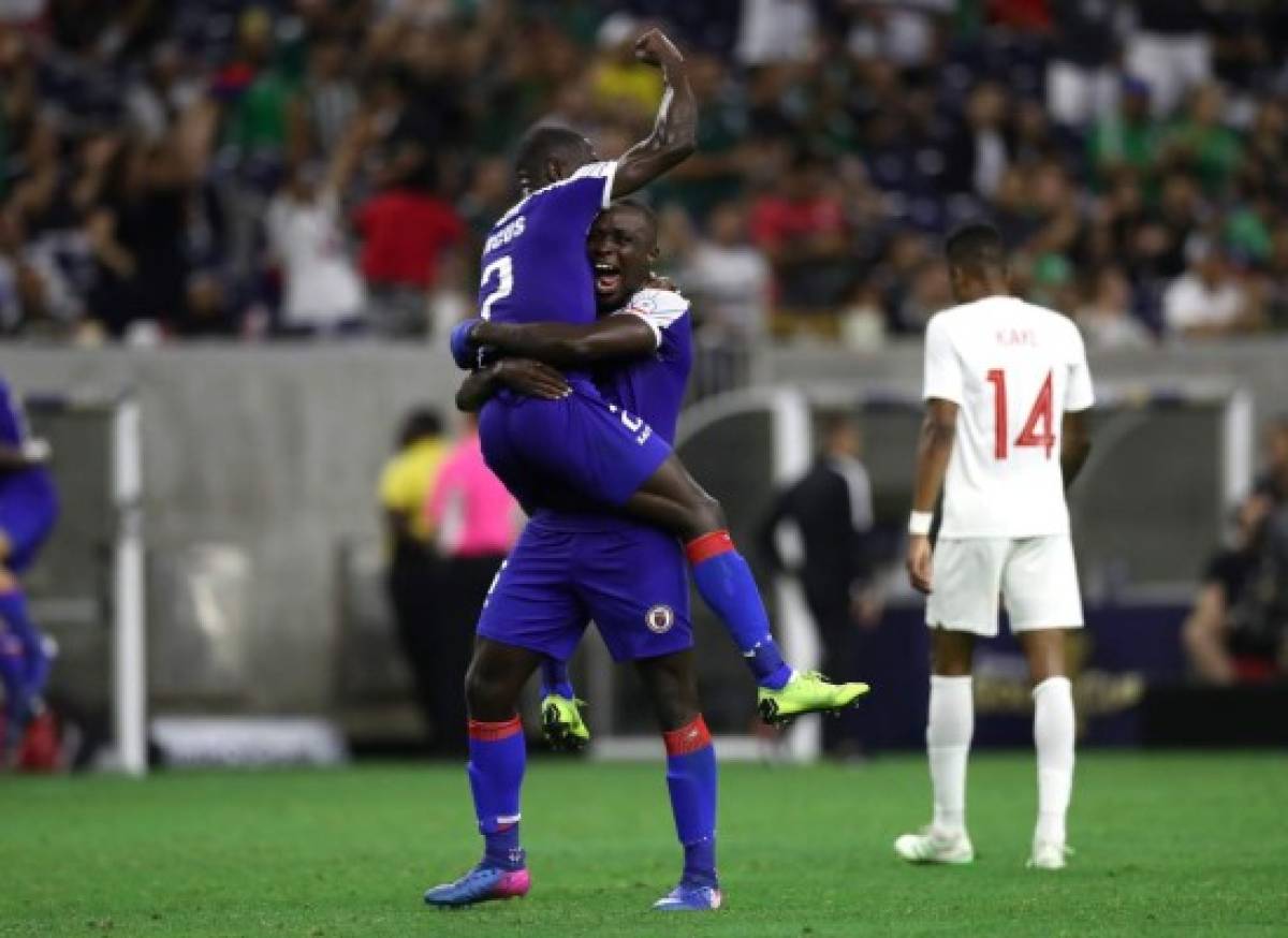 HOUSTON, TEXAS - JUNE 29: (L-R) Carlens Arcus #2 and Andrew Jean Baptiste #16 of Haiti celebrate a 3-2 win in front of Mark-anthony Kaye #14 of Canada during the quarterfinals of the 2019 CONCACAF Gold Cup at NRG Stadium on June 29, 2019 in Houston, Texas. Ronald Martinez/Getty Images/AFP