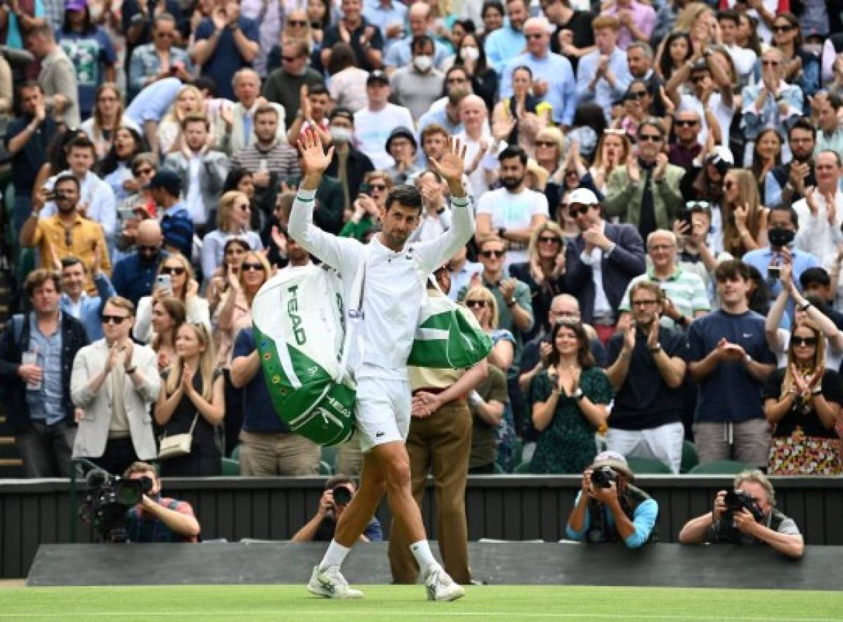 Serbia's Novak Djokovic acknowledges the applause as he leaves the court after winning against Hungary's Marton Fucsovics during their men's quarter-finals match on the ninth day of the 2021 Wimbledon Championships at The All England Tennis Club in Wimbledon, southwest London, on July 7, 2021. (Photo by Glyn KIRK / AFP) / RESTRICTED TO EDITORIAL USE
