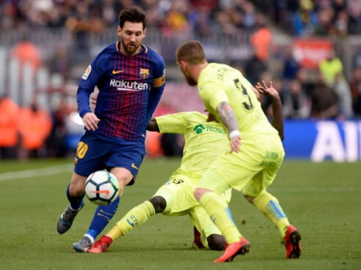 Barcelona's Argentinian forward Lionel Messi (L) vies with Getafe's Senegalese forward Amath Ndiaye Diedhiou (C) during the Spanish league football match between FC Barcelona and Getafe CF at the Camp Nou stadium in Barcelona on February 11, 2018. / AFP PHOTO / Josep LAGO