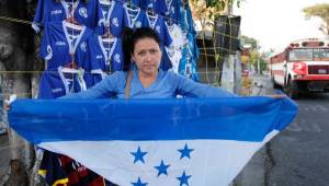 Michelle de Molina nos muestra la bandera de Honduras que se puede adquirir en las afueras del estadio Cuscatlán. Fotos Neptalí Romero, Enviado Especial.
