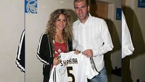 Shakira y Zidane posando con una camiseta del Real Madrid.