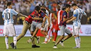El momento en que Messi ayudó al fan cuando entró al campo. Foto AFP.