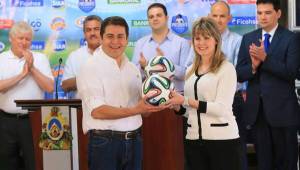 La directora regional de Diunsa, Adda Molina, en el momento que le entregaba el balón al Presidente Juan Orlando.