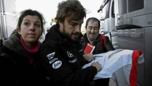 Fernando Alonso firmando autógrafo minutos antes de iniciar su práctica. (Fotos: EFE)