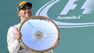 Lewis Hamilton posando con su primer premio de la temporada. (Fotos. EFE)