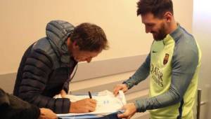 Lange firmando la camiseta argentina de Lionel Messi.