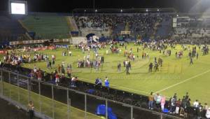 La afición al escuchar y sentir gas lacrimógeno, se metieron a la cancha. Foto Ronald Aceituno.