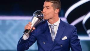 Cristiano Ronaldo besando el premio The Best otorgado por la FIFA.