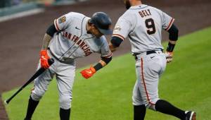 Brandon Belt es felicitado por su compañero luego de conectar un jonrón de tres carreras en la cuarta entrada del duelo ante los Rockies de Colorado.