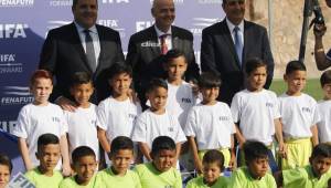 Gianni Infantino junto a Victor Montagliani y Jorge Slaomón posando con niños en el Estadio El Birichiche. Foto Ronald Aceituno