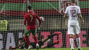 Portugal's forward Cristiano Ronaldo (C) scores a goal during the international friendly football match between Portugal and Qatar at the Algarve stadium in Loule, near Faro, southern Portugal, on October 9, 2021. (Photo by CARLOS COSTA / AFP)