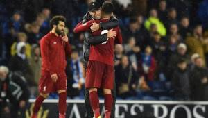 Liverpool's German manager Jurgen Klopp (C) embraces Liverpool's Brazilian midfielder Roberto Firmino (R) on the pitch after the English Premier League football match between Brighton and Hove Albion and Liverpool at the American Express Community Stadium in Brighton, southern England on January 12, 2019. - Liverpool won the game 1-0. (Photo by Glyn KIRK / AFP) / RESTRICTED TO EDITORIAL USE. No use with unauthorized audio, video, data, fixture lists, club/league logos or 'live' services. Online in-match use limited to 120 images. An additional 40 images may be used in extra time. No video emulation. Social media in-match use limited to 120 images. An additional 40 images may be used in extra time. No use in betting publications, games or single club/league/player publications. /