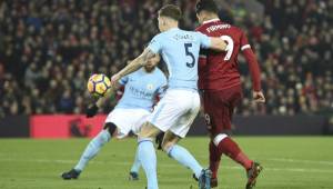 Liverpool's Brazilian midfielder Roberto Firmino (R) chips the ball up to score their second goal to take the lead 2-1 during the English Premier League football match between Liverpool and Manchester City at Anfield in Liverpool, north west England on January 14, 2018. / AFP PHOTO / Oli SCARFF / RESTRICTED TO EDITORIAL USE. No use with unauthorized audio, video, data, fixture lists, club/league logos or 'live' services. Online in-match use limited to 75 images, no video emulation. No use in betting, games or single club/league/player publications. /