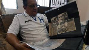 Honduran lawyer Marco Antonio 'Tonin' Mendoza, former capitan of the 1969 Honduran football team, shows pictures at his home in Tegucigalpa, on June 22, 2019. - 2019 commemorates 50th anniversary of the so-called 1969 'football war' between El Salvador and Honduras. (Photo by ORLANDO SIERRA / AFP)