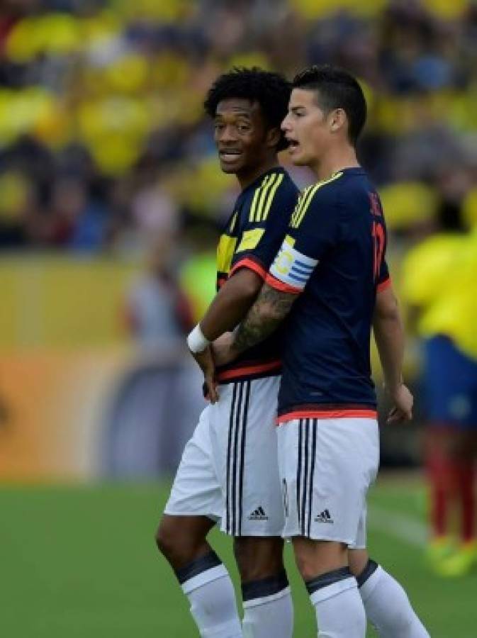 Colombia's midfielders James Rodriguez (R) and Juan Cuadrado chat during their 2018 FIFA World Cup qualifier football match against Ecuador in Quito, on March 28, 2017. / AFP PHOTO / Rodrigo BUENDIA