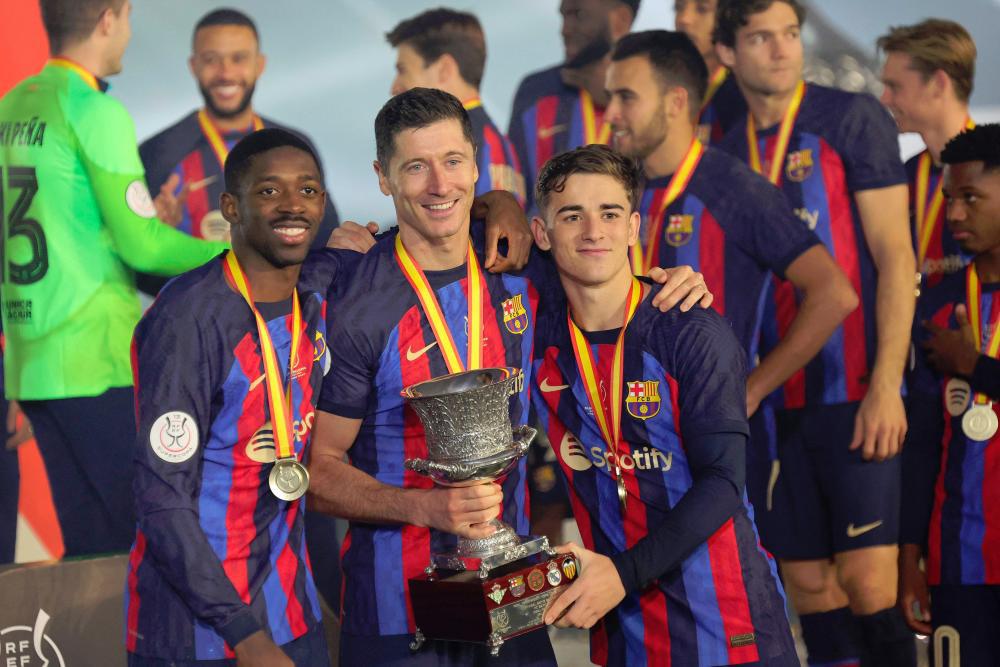 Dembélé, Lewandowski y Gavi posando con el título de la Supercopa de España.