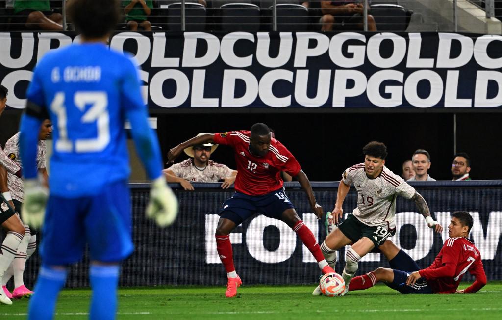 Joel Campbell intenta quitarse la marcha de Jorge Sánchez.
