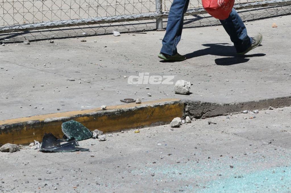 Carros destruidos, piedras y testimonios; así lucen las calles tras batalla entre aficionados de Motagua y Olimpia