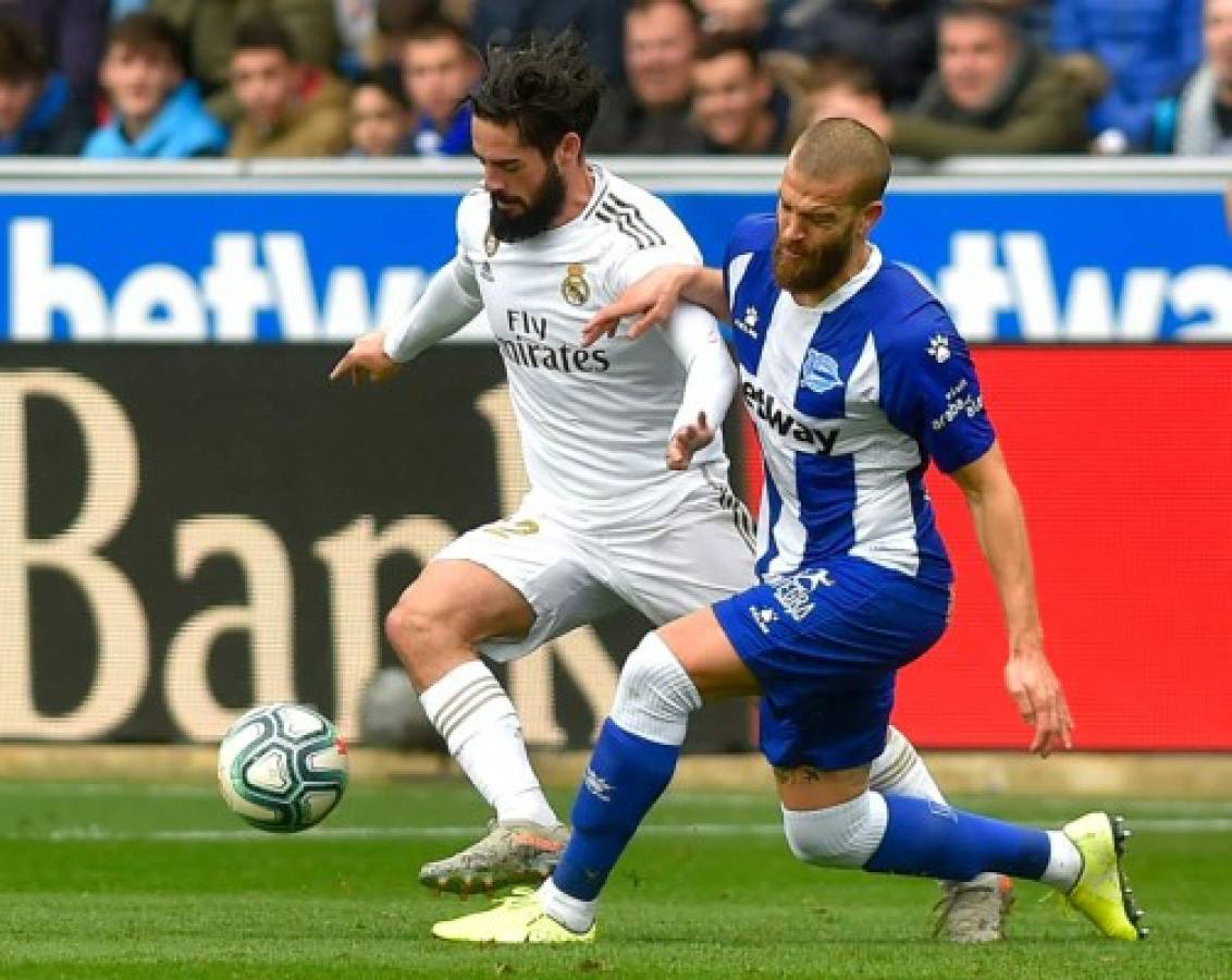 Alaves' Spanish defender Victor Laguardia Cisneros (R) vies with AReal Madrid's Spanish midfielder Isco during the Spanish league football match between Deportivo Alaves and Real Madrid CF at the Mendizorroza stadium in Vitoria on November 30, 2019. (Photo by ANDER GILLENEA / AFP)