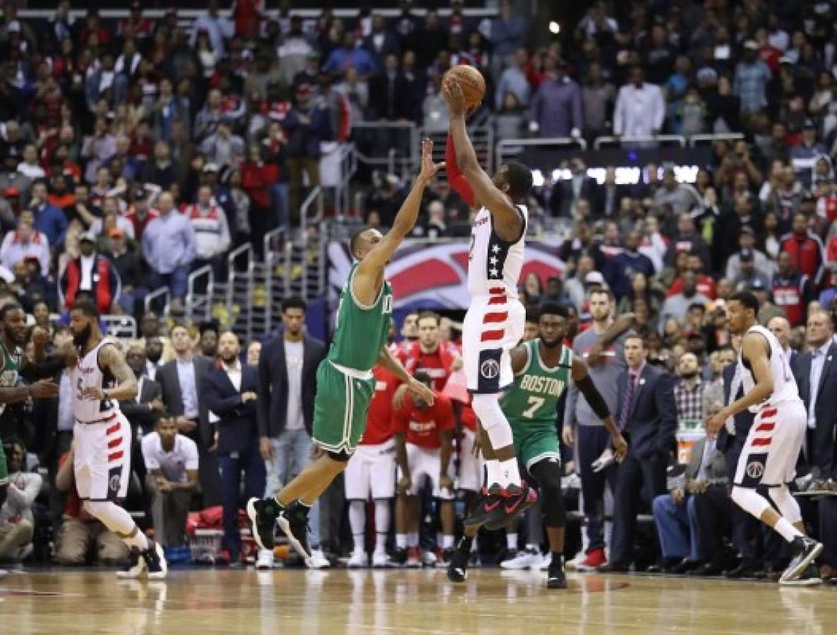 WASHINGTON, DC - MAY 12: John Wall #2 of the Washington Wizards shoots the game-winning three-point basket against Avery Bradley #0 of the Boston Celtics during Game Six of the NBA Eastern Conference Semi-Finals at Verizon Center on May 12, 2017 in Washington, DC. NOTE TO USER: User expressly acknowledges and agrees that, by downloading and or using this photograph, User is consenting to the terms and conditions of the Getty Images License Agreement. Rob Carr/Getty Images/AFP