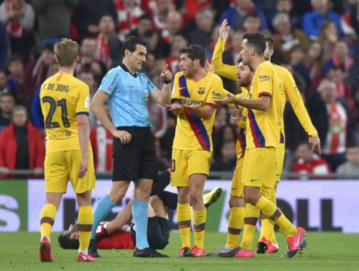 Barcelona's players speak with Spanish referee Martinez Manuera during the Spanish Copa del Rey (King's Cup) quarter-final football match Athletic Club Bilbao against FC Barcelona at the San Mames stadium in Bilbao on February 06, 2020. (Photo by ANDER GILLENEA / AFP)