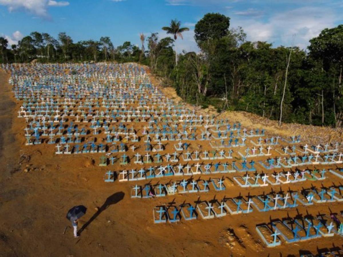 (FILES) This file photo taken on November 21, 2020 shows an aerial view of the burial site reserved for victims of the COVID-19 pandemic at the Nossa Senhora Aparecida cemetery in Manaus, in the Amazon forest in Brazil. - People are turning to online support groups after losing relatives to COVID-19, the novel coronavirus which has caused 190,000 deaths in Brazil by December 27, 2020. (Photo by MICHAEL DANTAS / AFP)