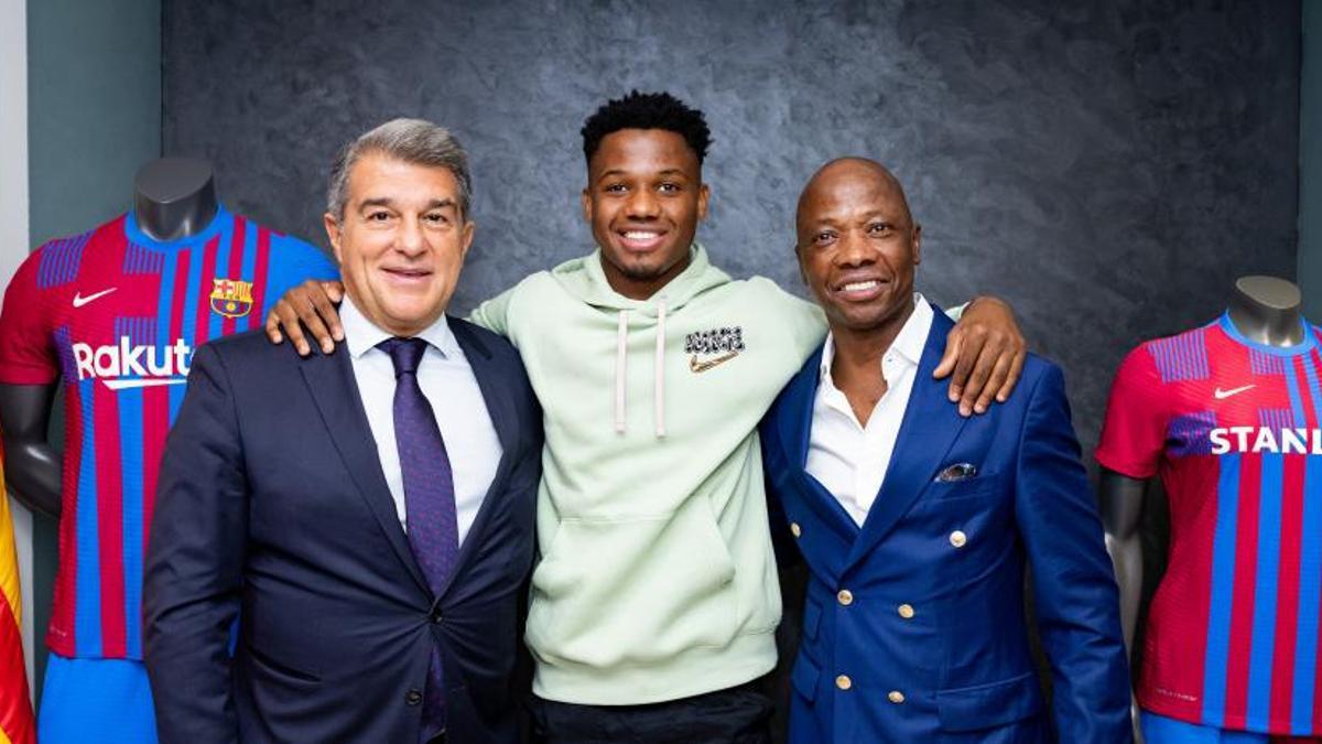 Ansu Fati posando con el presidente Laporta y su padre, Bori Fati.