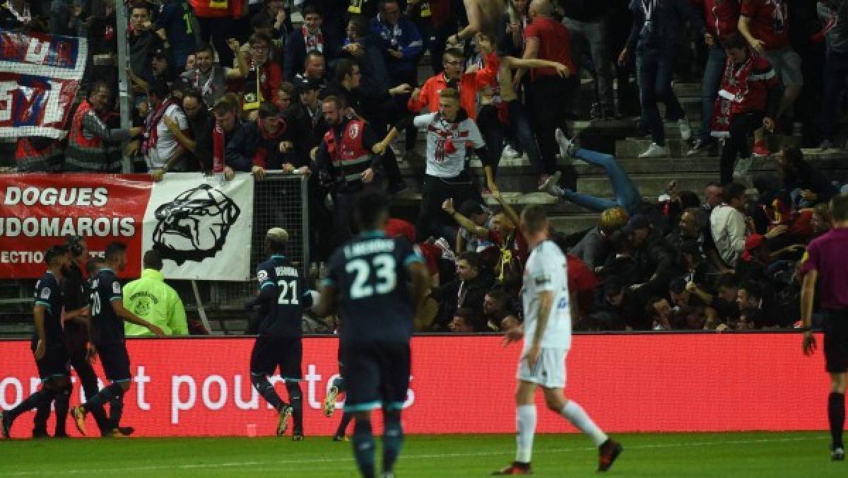 LOSC's supporters react as their tribune collapse following the goal by LOSC French defender Fode Ballo-Toure during the French L1 football match between Amiens and Lille LOSC on September 30, 2017 at the Licorne stadium in Amiens.Several Lille supporters were hurt in Amiens when a stadium barrier collapsed in the away section as the visiting fans celebrated the opening goal of the match. The Ligue 1 fixture was interrupted in the 16th minute after LOSC French defender Fode Ballo-Toure's goal sparked celebrations that caused a fence separating the fans from the pitch to crumble under their weight. / AFP PHOTO / FRANCOIS LO PRESTI