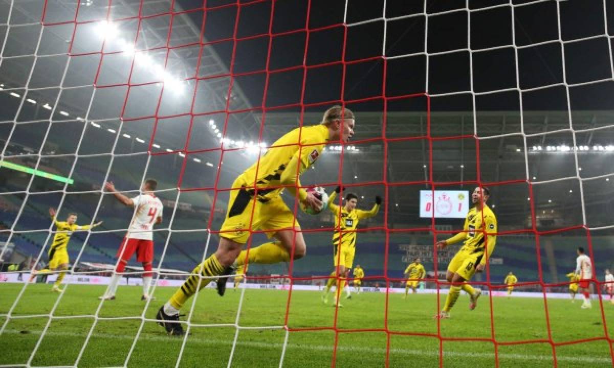 Dortmund's Norwegian forward Erling Braut Haaland (C) celebrates scoring his team's second goal during the German first division Bundesliga football match RB Leipzig vs Borussia Dortmund in Leipzig, on January 9, 2021. (Photo by Ronny Hartmann / various sources / AFP) / DFL REGULATIONS PROHIBIT ANY USE OF PHOTOGRAPHS AS IMAGE SEQUENCES AND/OR QUASI-VIDEO