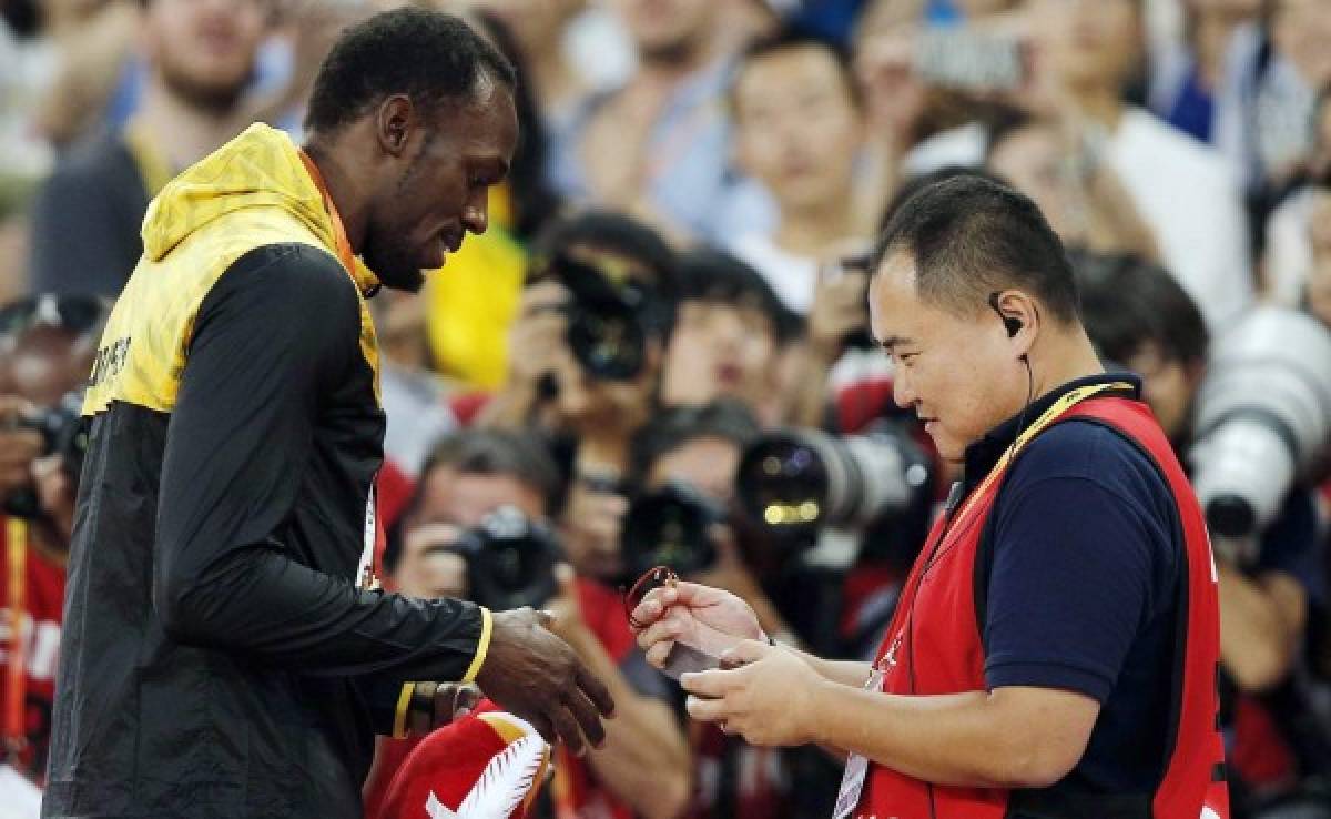 Usaint Bolt recibe una pulsera del camarógrafo que le atropelló
