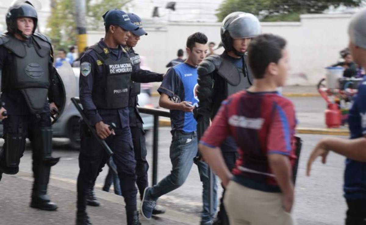 Policía detiene a aficionado por despojar a seguidor del Olimpia de su camisa