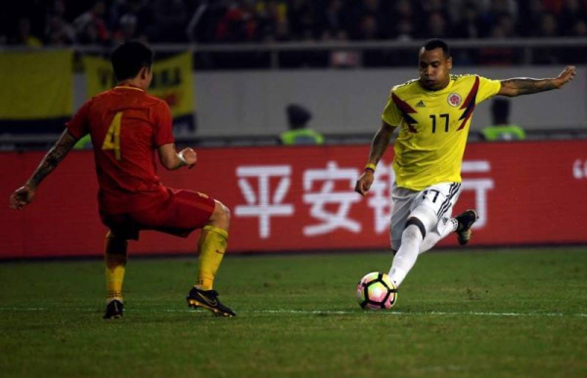 CH01 CHONGQING (CHINA). 14/11/2017 El delantero colombiano Dayro Moreno se lleva el balón ante el jugador chino Juang Zhipang durantel partido amistoso que han disputado hoy ambas selecciones en la ciudad china de Chongqing. EFE/GAO GE