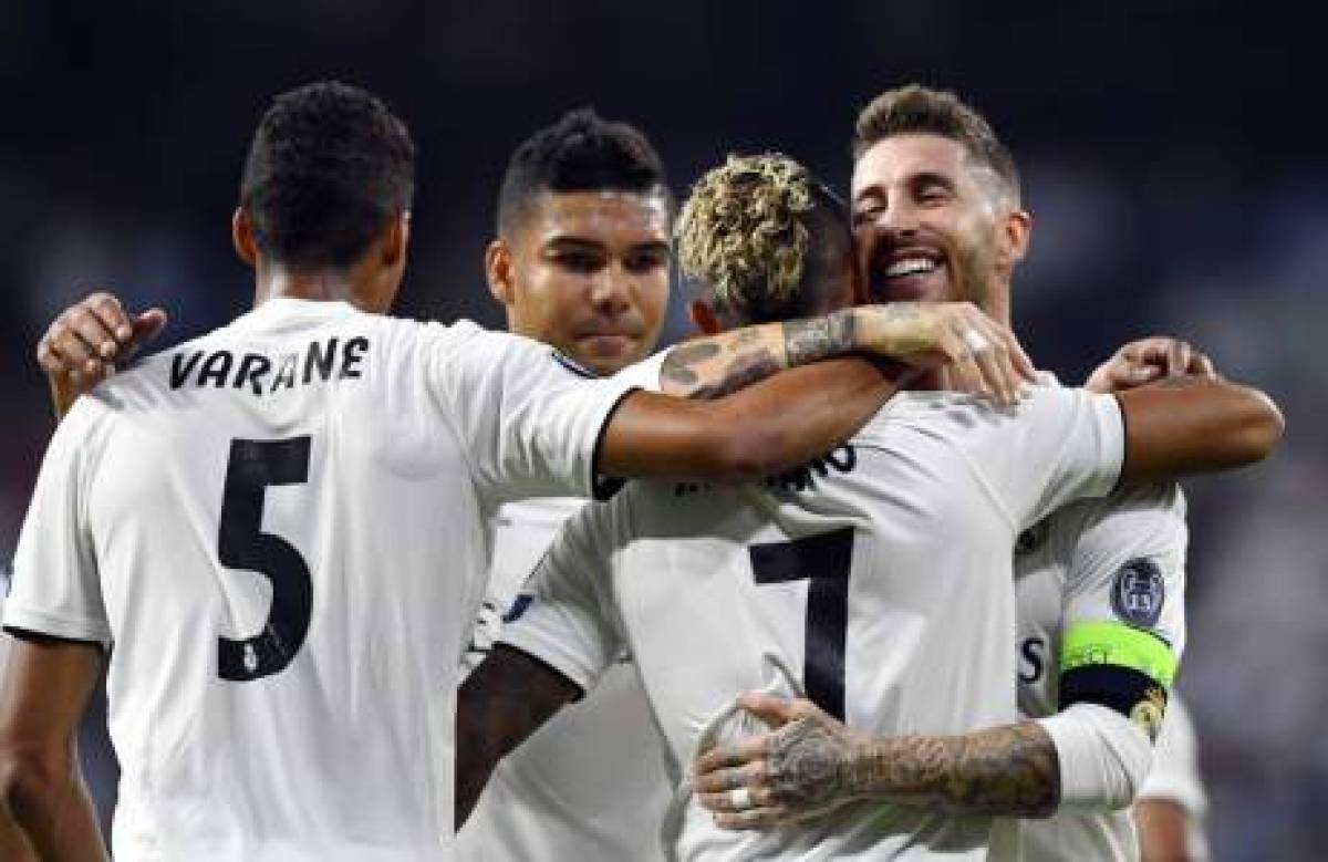Real Madrid's Spanish-Dominican forward Mariano (2R) celebrates his goal with Real Madrid's Spanish defender Sergio Ramos (R) during the UEFA Champions League group G football match between Real Madrid CF and AS Roma at the Santiago Bernabeu stadium in Madrid on September 19, 2018. / AFP PHOTO / GABRIEL BOUYS
