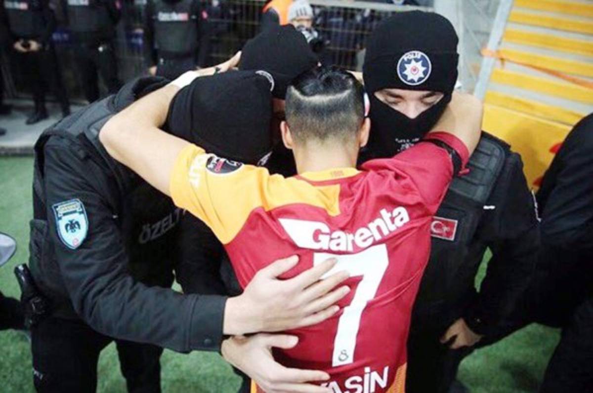 Jugador del Galatasaray celebra su gol con tres agentes de la policía