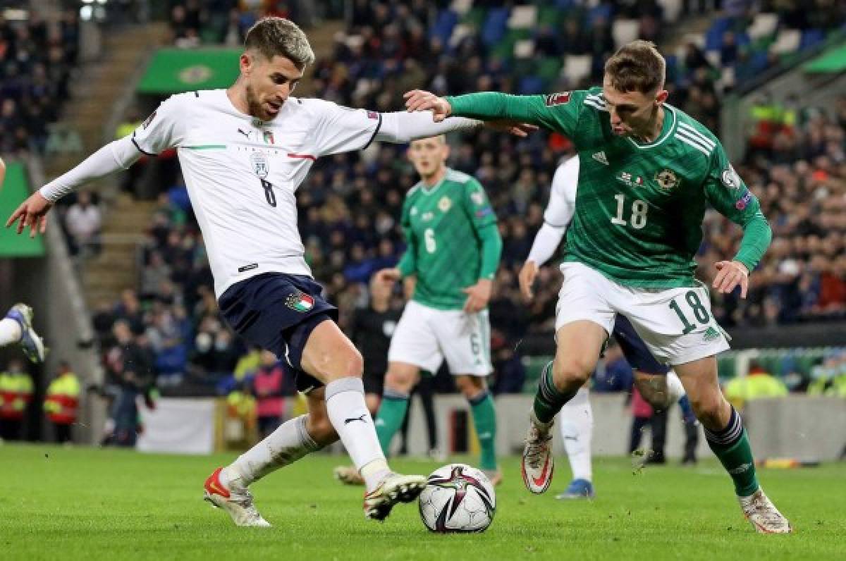 Italy's midfielder Jorginho (L) vies with Northern Ireland's midfielder Gavin Whyte during the FIFA World Cup 2022 round one Group C qualification football match between Northern Ireland and Italy at Windsor Park in Belfast, Northern Ireland on November 15, 2021. (Photo by PAUL FAITH / AFP)