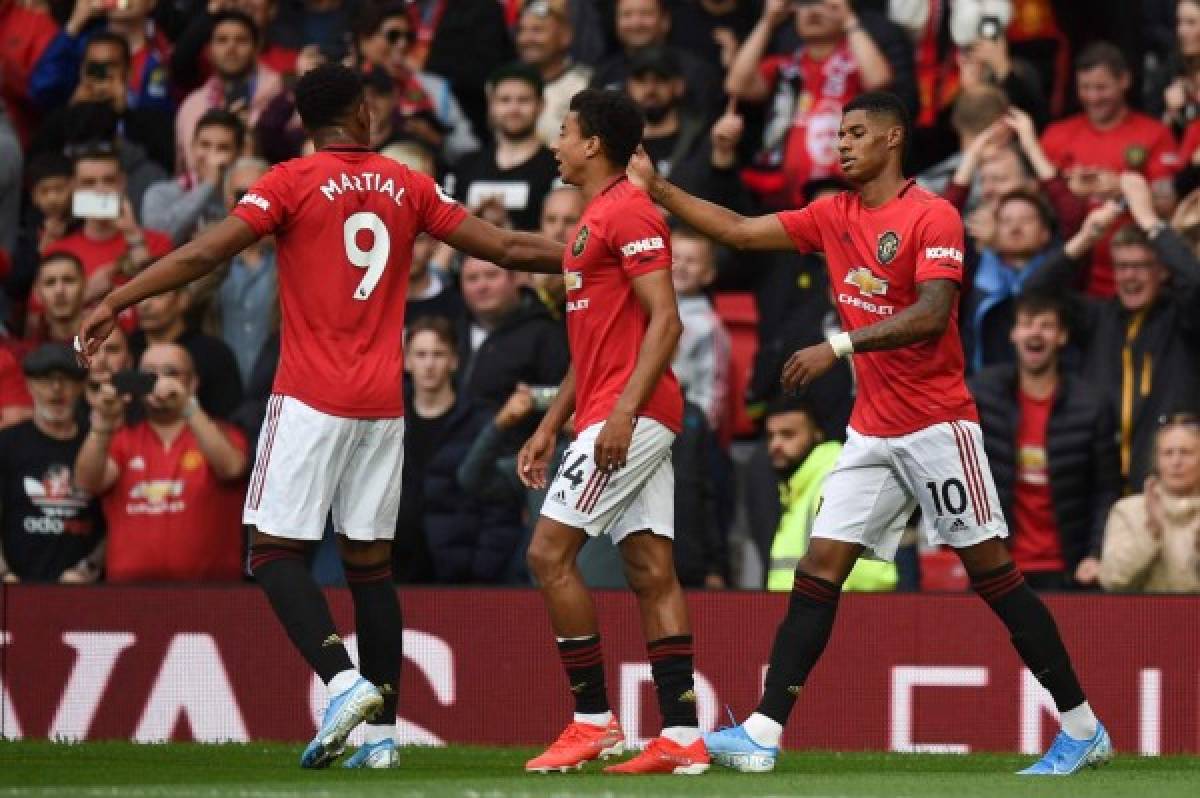 Manchester United's English striker Marcus Rashford (R) celebrates with teammates after scoring the opening goal from the penalty spot during the English Premier League football match between Manchester United and Chelsea at Old Trafford in Manchester, north west England, on August 11, 2019. (Photo by Oli SCARFF / AFP) / RESTRICTED TO EDITORIAL USE. No use with unauthorized audio, video, data, fixture lists, club/league logos or 'live' services. Online in-match use limited to 120 images. An additional 40 images may be used in extra time. No video emulation. Social media in-match use limited to 120 images. An additional 40 images may be used in extra time. No use in betting publications, games or single club/league/player publications. /