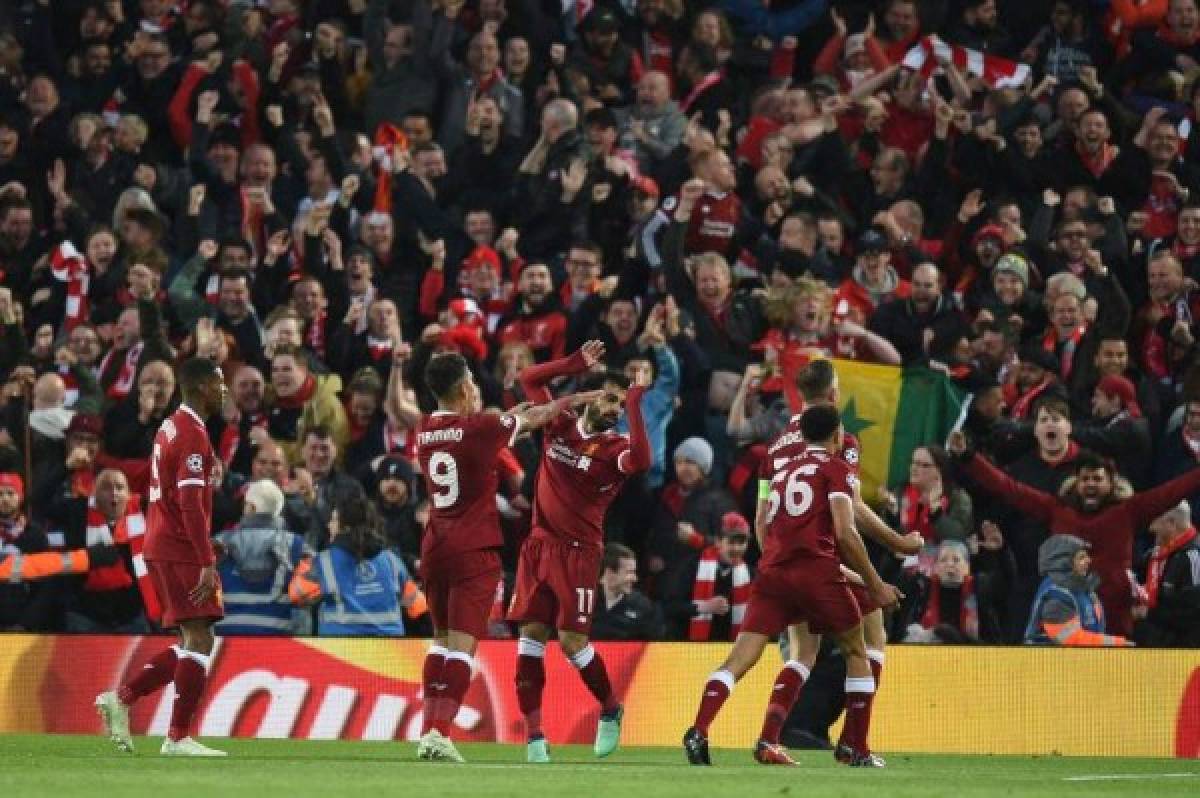 Liverpool's Egyptian midfielder Mohamed Salah (C) celebrates with teammates after scoring their first goal during the UEFA Champions League first leg semi-final football match between Liverpool and Roma at Anfield stadium in Liverpool, north west England on April 24, 2018. / AFP PHOTO / Oli SCARFF