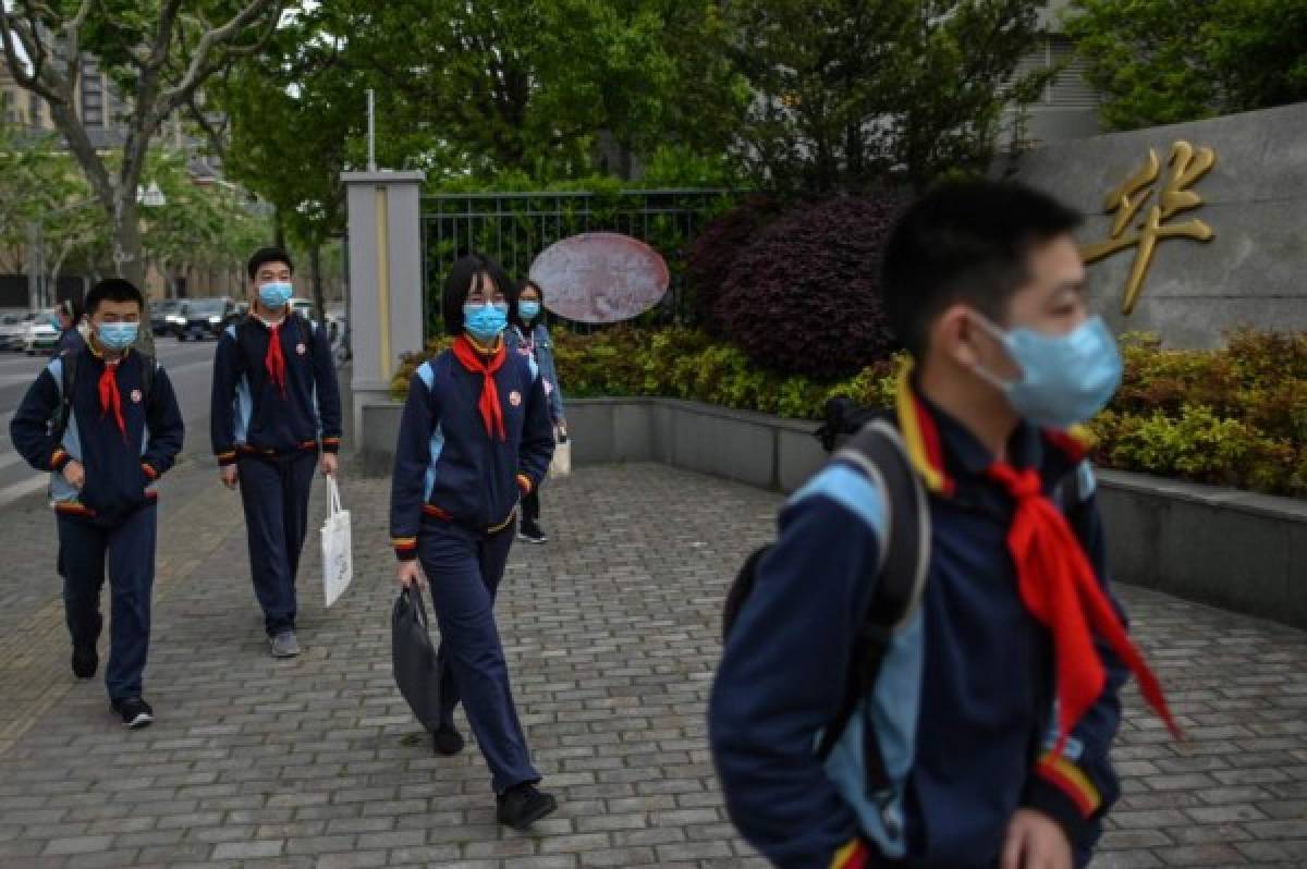 Students wearing face masks arrive at the Huayu Middle School in Shanghai on April 27, 2020. - Students returned to class on April 27 for the first time since schools were closed down in January as part of efforts to stop the spread of the COVID-19 coronavirus. (Photo by Hector RETAMAL / AFP)