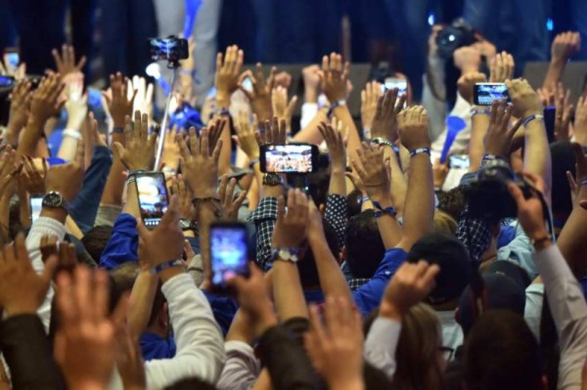 Supporters of Honduran President and presidential candidate Juan Orlando Hernandez are in a festive mood in Tegucigalpa after the general election on November 26, 2017. Honduras' six million voters are to cast ballots in a controversial election Sunday in which President Juan Orlando Hernandez is seeking a second mandate despite a constitutional one-term limit. This small country is at the heart of Central America's 'triangle of death,' an area plagued by gangs and poverty. / AFP PHOTO / RODRIGO ARANGUA