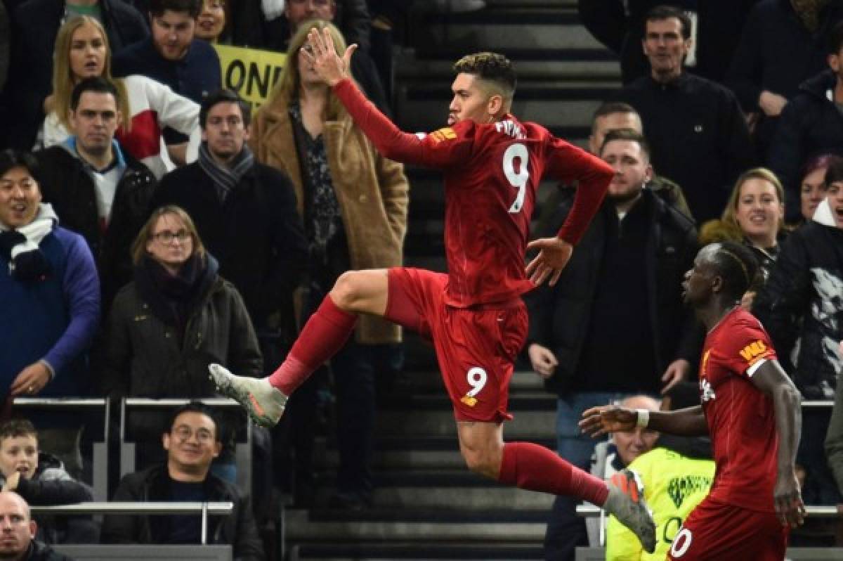 Liverpool's Brazilian midfielder Roberto Firmino (L) celebrates scoring the opening goal during the English Premier League football match between Tottenham Hotspur and Liverpool at Tottenham Hotspur Stadium in London, on January 11, 2020. (Photo by Glyn KIRK / AFP) / RESTRICTED TO EDITORIAL USE. No use with unauthorized audio, video, data, fixture lists, club/league logos or 'live' services. Online in-match use limited to 120 images. An additional 40 images may be used in extra time. No video emulation. Social media in-match use limited to 120 images. An additional 40 images may be used in extra time. No use in betting publications, games or single club/league/player publications. /