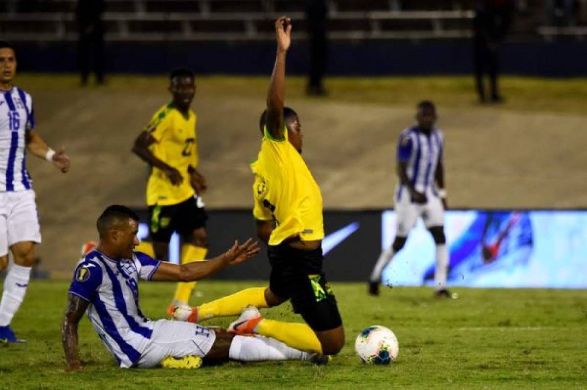 Honduras's Luis Garrido (L) and Jamaica's Leon Bailey (R) clash during the 2019 Concacaf Gold Cup match between Jamaica and Honduras, on June 17, 2019 at Independence Park in Kingston. (Photo by CHANDAN KHANNA / AFP)