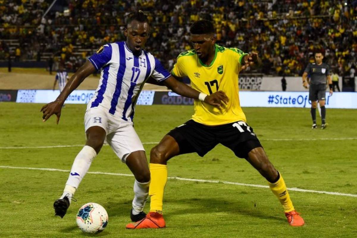 Honduras's Alberth Elis (L) and Jamaica's Damion Lowe fight for the ball during the 2019 Concacaf Gold Cup match between Jamaica and Honduras, on June 17, 2019 at Independence Park in Kingston. (Photo by CHANDAN KHANNA / AFP)