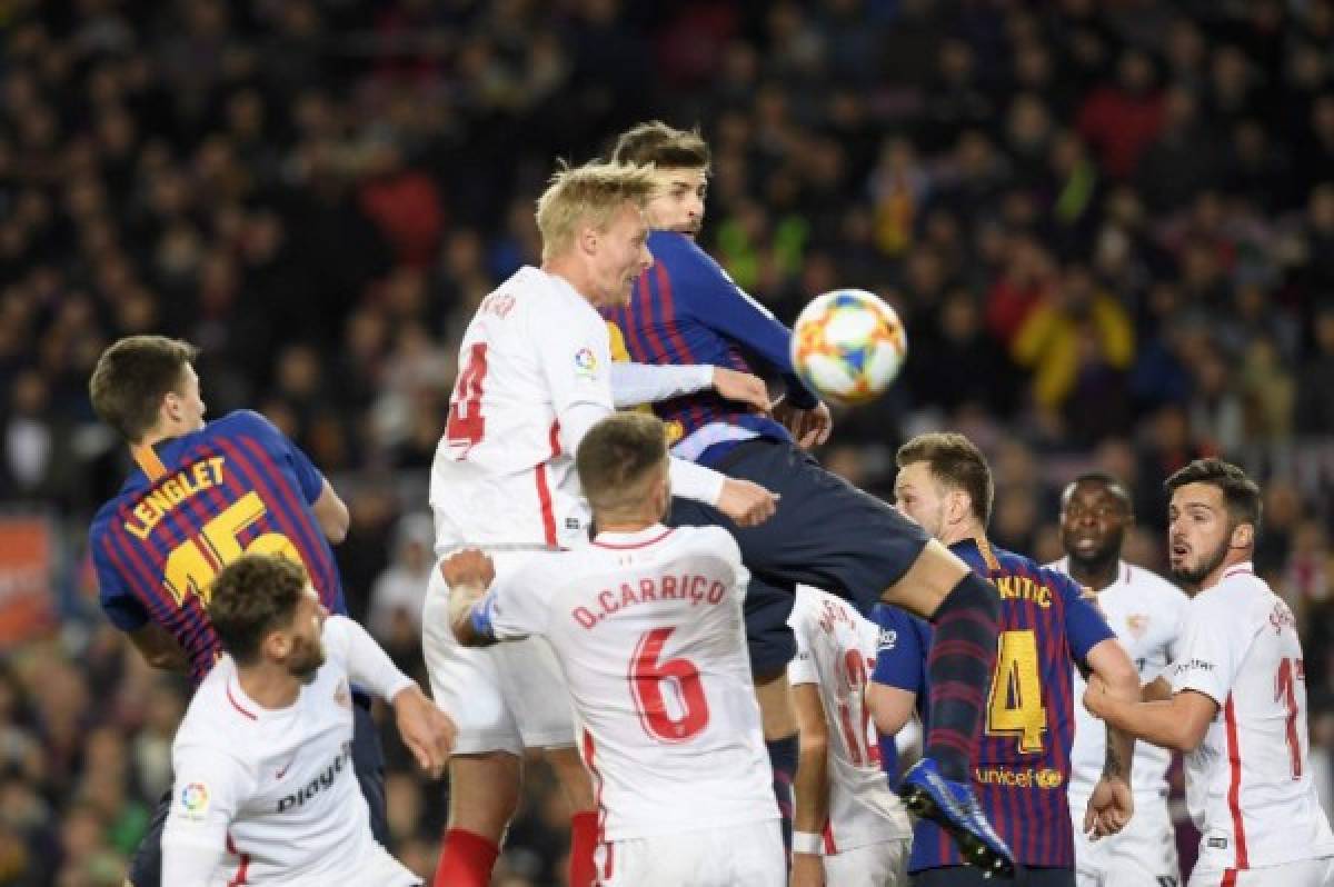 Barcelona's Spanish defender Gerard Pique (R) and Sevilla's Danish defender Simon Kjaer (L) jump for the ball during the Spanish Copa del Rey (King's Cup) quarter-final second leg football match between Barcelona and Sevilla at the Camp Nou stadium in Barcelona on January 30, 2019. (Photo by LLUIS GENE / AFP)