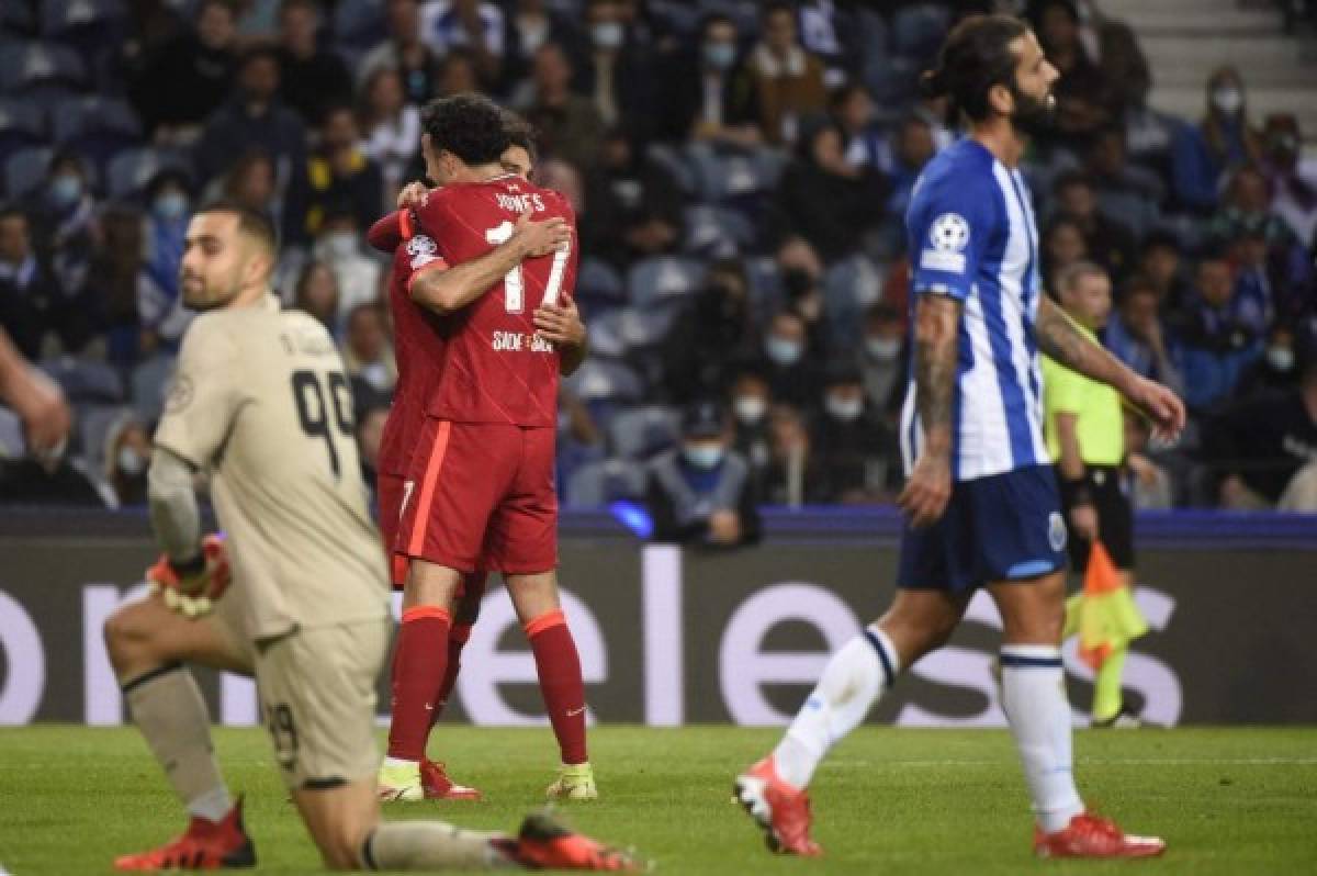 Liverpool's Egyptian forward Mohamed Salah celebrates scoring his team's second goal with Liverpool's English midfielder Curtis Jones during the UEFA Champions League first round group B footbal match between Porto and Liverpool at the Dragao stadium in Porto on September 28, 2021. (Photo by MIGUEL RIOPA / AFP)