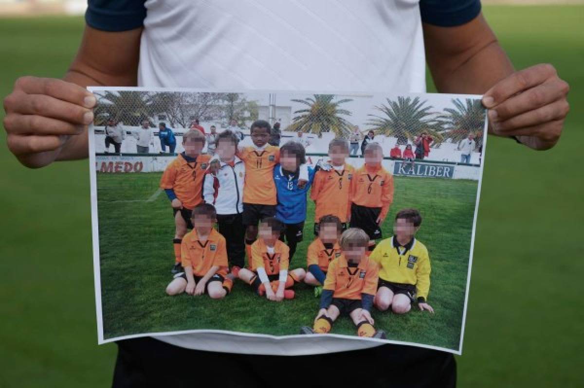 Jordi Figueroa, head coach at the 'Peloteros' football school in Herrera, Sevilla, shows an old picture of Bissau-Guinean football player Ansu Fati with teammates, on September 18, 2019. - Ansu Fati has made a long trip from the fields where he played as a kid in Guinea Bissau to Barcelona's Camp Nou stadium where the 16-year-old has exploded onto the scene. (Photo by CRISTINA QUICLER / AFP) / RESTRICTED TO EDITORIAL USE - NO MARKETING NO ADVERTISING CAMPAIGNS - DISTRIBUTED AS A SERVICE TO CLIENTS -