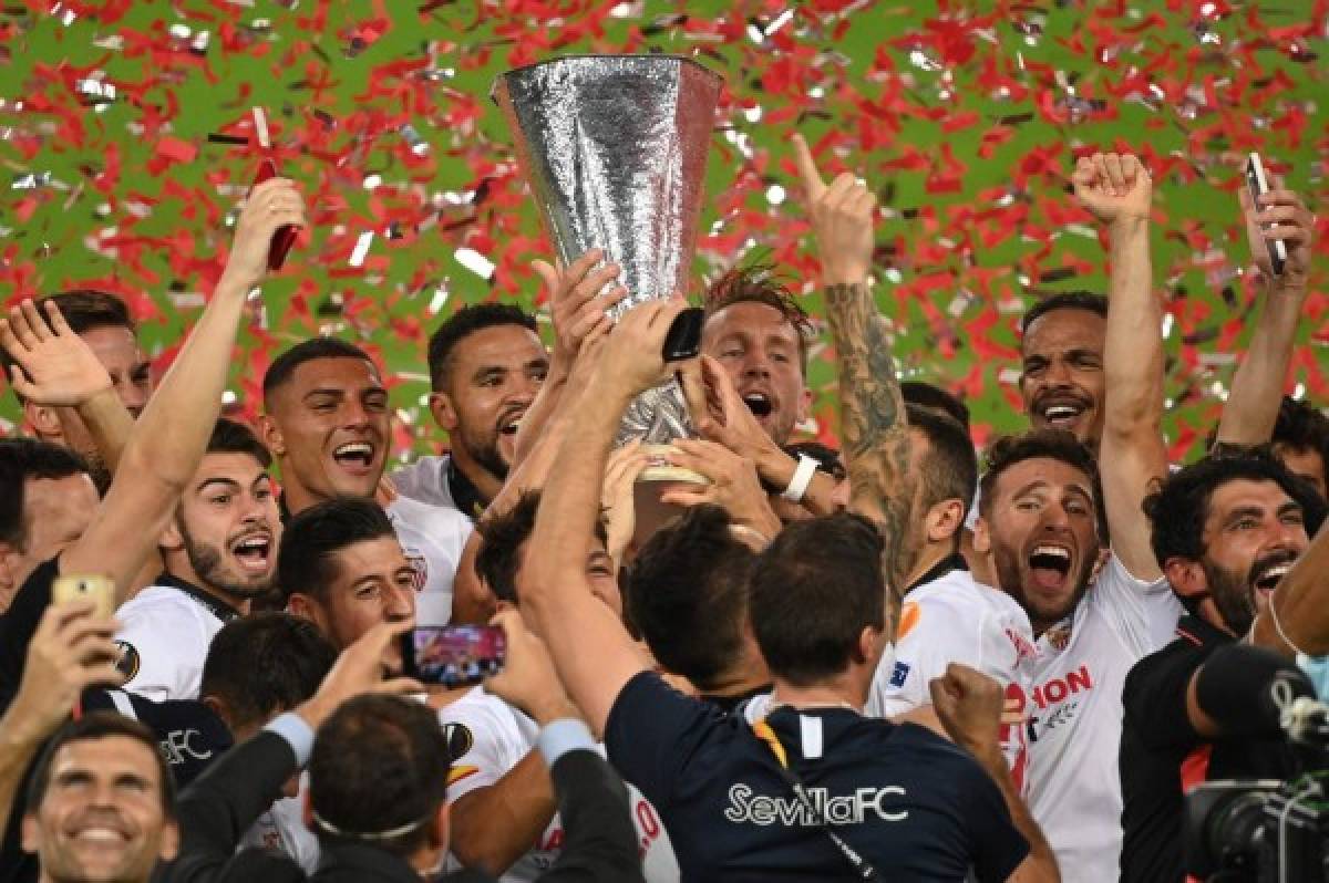 Sevilla's players celebrate with the trophy after winning the UEFA Europa League final football match Sevilla v Inter Milan on August 21, 2020, in Cologne, western Germany. (Photo by Ina Fassbender / POOL / AFP)