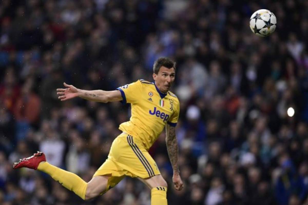 Juventus' Croatian forward Mario Mandzukic scores during the UEFA Champions League quarter-final second leg football match between Real Madrid CF and Juventus FC at the Santiago Bernabeu stadium in Madrid on April 11, 2018. / AFP PHOTO / JAVIER SORIANO