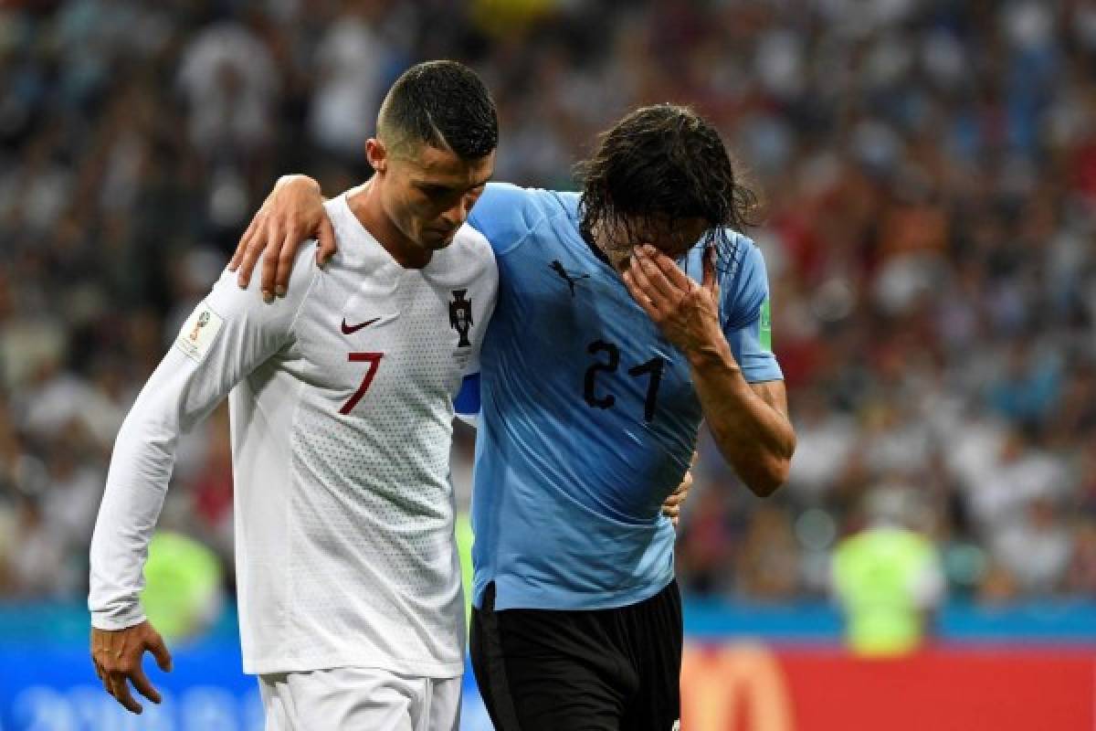 Uruguay's forward Edinson Cavani (2ndL) leaves the pitch comforted by Portugal's forward Cristiano Ronaldo during the Russia 2018 World Cup round of 16 football match between Uruguay and Portugal at the Fisht Stadium in Sochi on June 30, 2018. / AFP PHOTO / Jonathan NACKSTRAND / RESTRICTED TO EDITORIAL USE - NO MOBILE PUSH ALERTS/DOWNLOADS